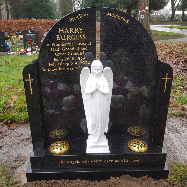 Gates of Heaven black granite memorial with crossed etched into the pillars of the gates. Marble angel stood between the gates, lettering in gold leaf