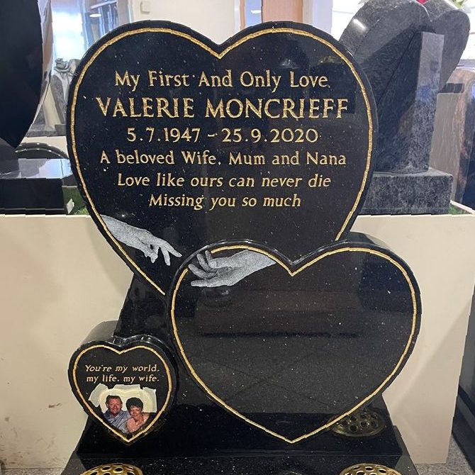 Three heart black granite memorial with hands stretching across the hearts, colour ceramic photoplaque, gold pinline around the hearts