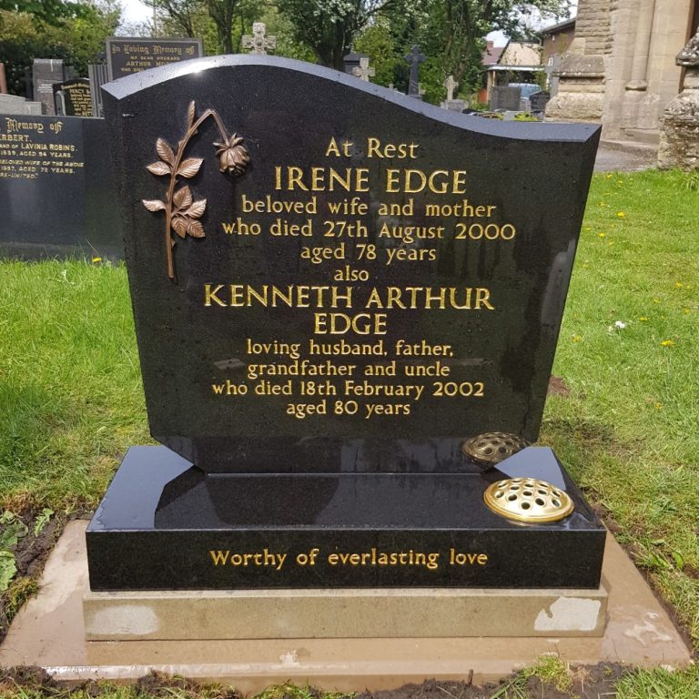 Black granite memorial with bronze rose and gilded letters on a yorkstone plinth