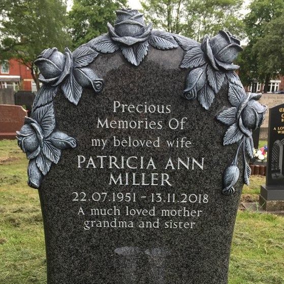 South African Grey granite memorial with large carved rose design. rounded sides to the headstone, silver lettering